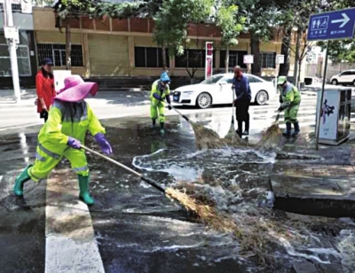环卫工清扫马路积水