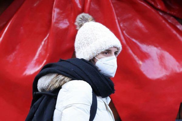 2021年12月9日，一名戴着口罩的购物者穿过伦敦市中心的考文特花园。（法新社）