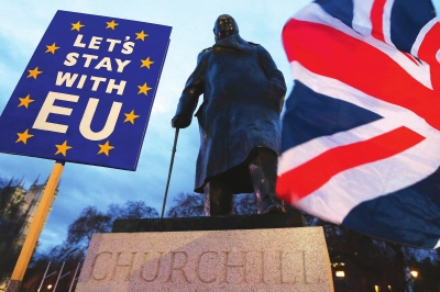 15日，民众在议会大厦外的英国前首相丘吉尔雕像前参加集会。标语牌上写着：“让我们与欧洲在一起。”新华社照片
