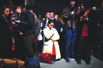 一位女子在巴黎圣母院附近祈祷