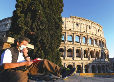 4月26日，一名戴着口罩的男子在意大利首都罗马的斗兽场附近看书。　　□新华社照片