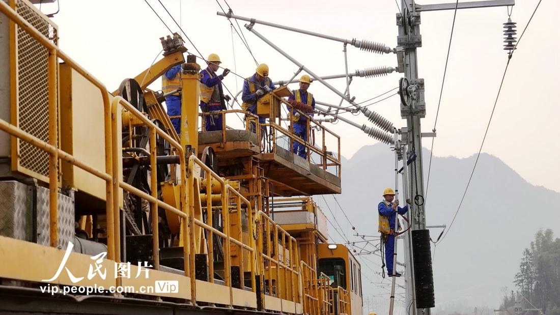 3月10日，工人们操作恒张力架线车在贵南高铁广西段架设接触网。