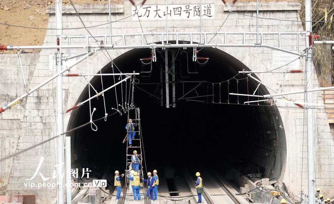 3月10日，贵南高铁广西段接触网完成架线后，施工人员在在替换接触网导线滑轮。