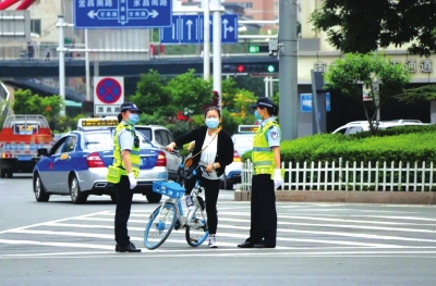 交警劝导骑自行车的市民