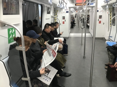 乘坐地铁的读者阅读《兰州日报》李昕摄